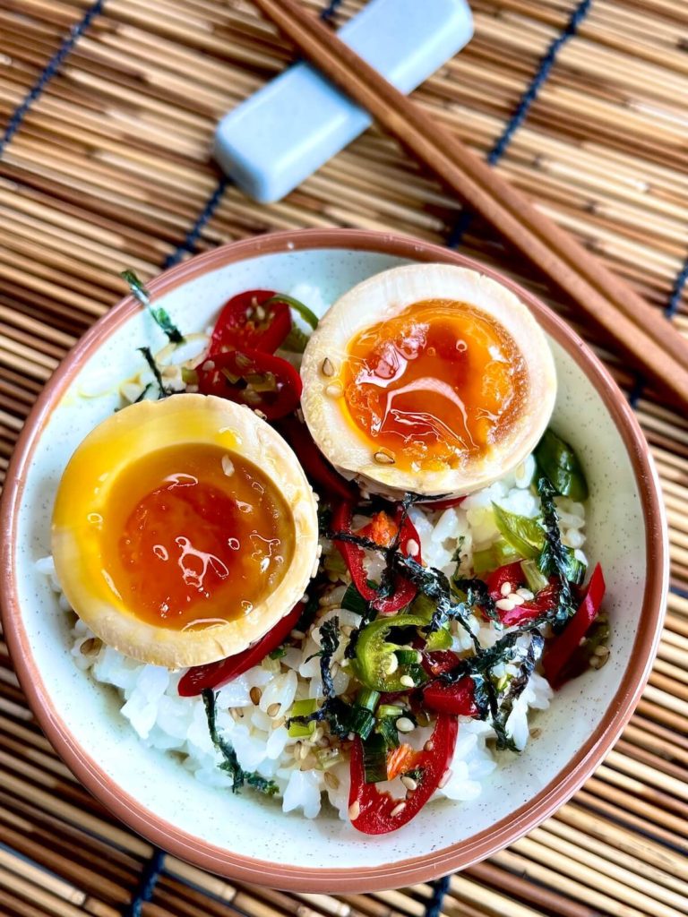 mayak eggs in a bowl on a bamboo mat