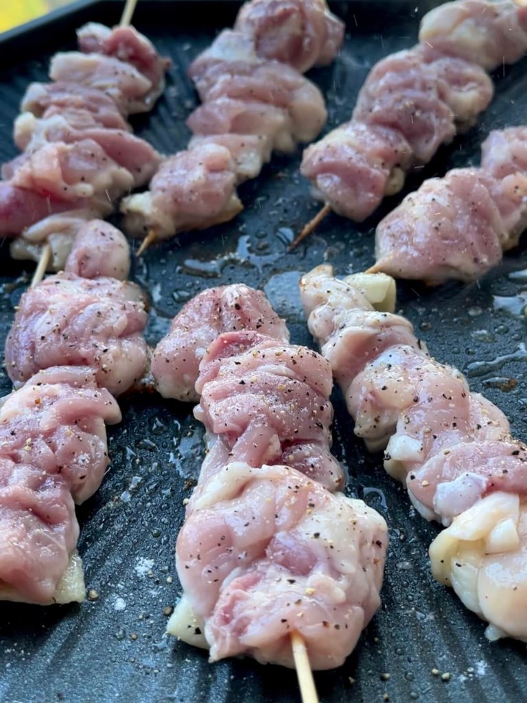 chicken skewers cooking on grill pan