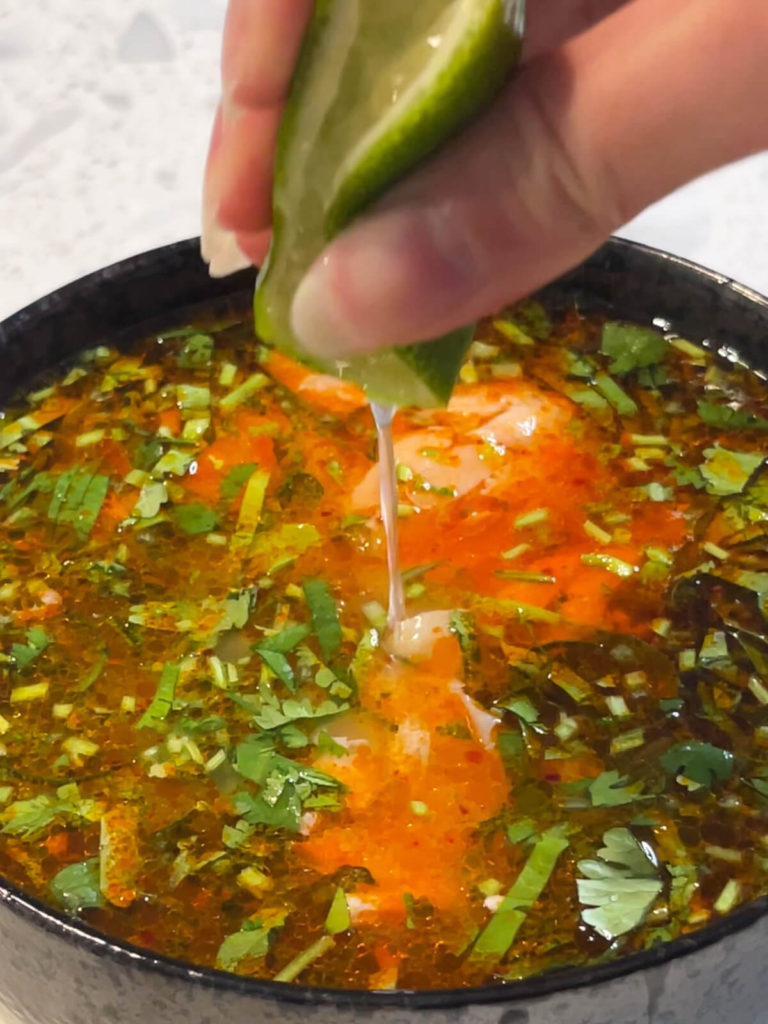 squeezing lime into salmon and rice soup